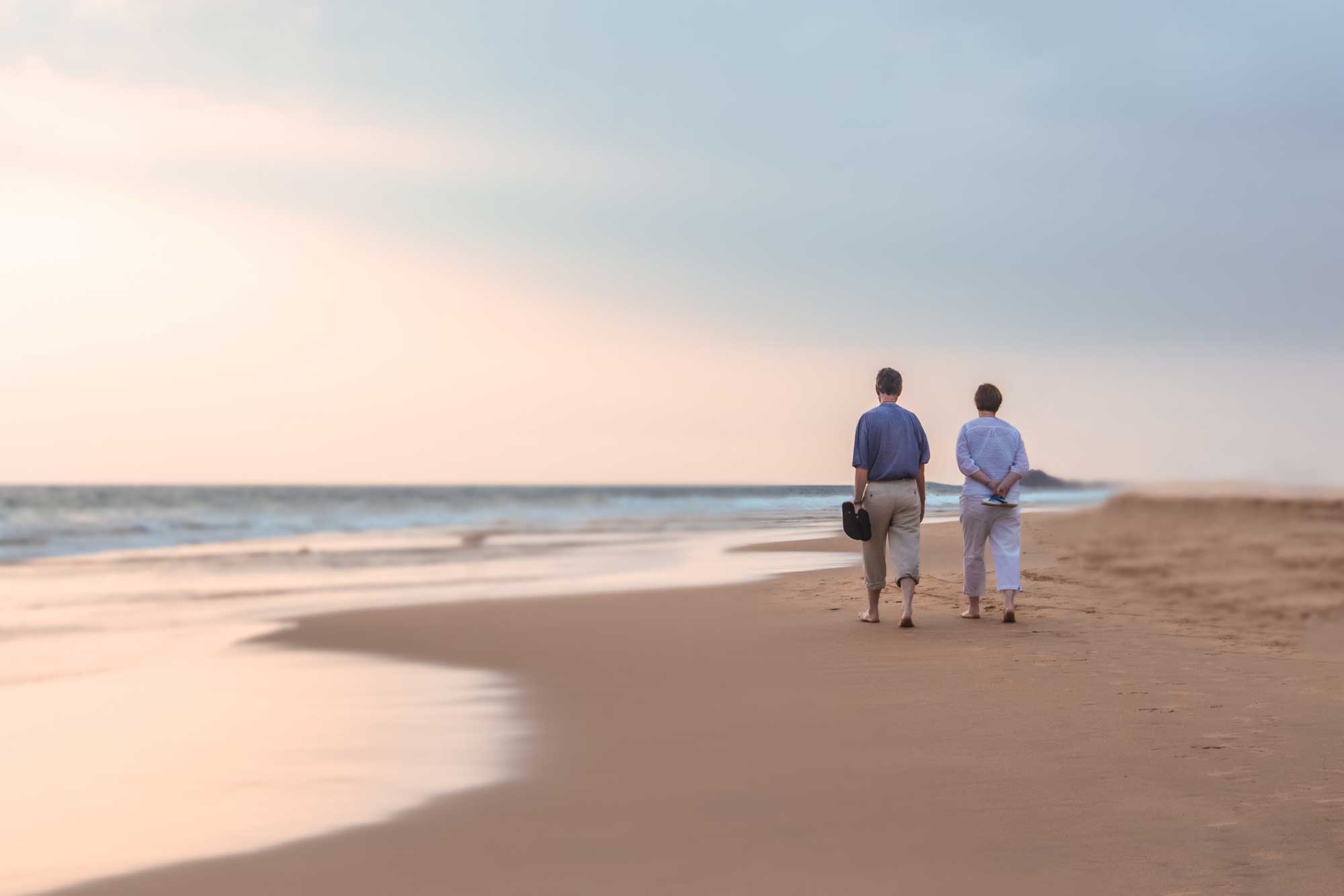 senior couple walking on beach